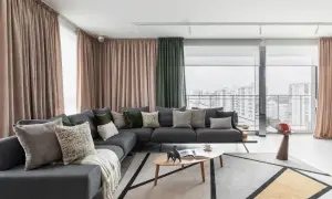 Nowoczesny salon z szarą sofą, geometrycznym dywanem i zasłonami. Idealne home staging przykłady, które zachwycają.