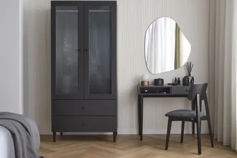 Eleganckie biurko w sypialni z lustrem i czarnym krzesłem obok szafy.