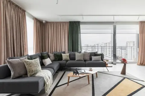 Nowoczesny salon z szarą sofą, geometrycznym dywanem i zasłonami. Idealne home staging przykłady, które zachwycają.