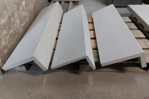 Gotowe elementy na wykładzinę na schody betonowe. Trzy szare stopnie leżą na drewnianych paletach.