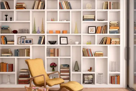 Domowa biblioteka pełna inspiracji. Wygodny fotel zachęca do czytania wśród książek i dekoracji.