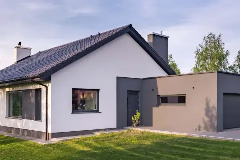 Nowoczesny dom z białymi i szarymi akcentami. Elewacja prezentuje ciekawe połączenie kolorów, tworząc harmonijną całość.