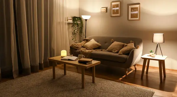 Salon inspiracje kolory: przytulny kącik z sofą, stolikiem i lampami. Ciepłe barwy tworzą relaksującą atmosferę.