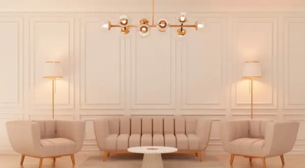 Elegancki salon w stylu glamour z beżową kanapą, dwoma fotelami, okrągłym stolikiem i złotą lampą.
