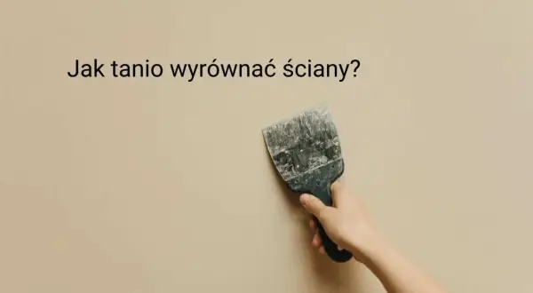 Ręka trzyma szpachelkę przy beżowej ścianie, sugerując, jak tanio wyrównać ściany.