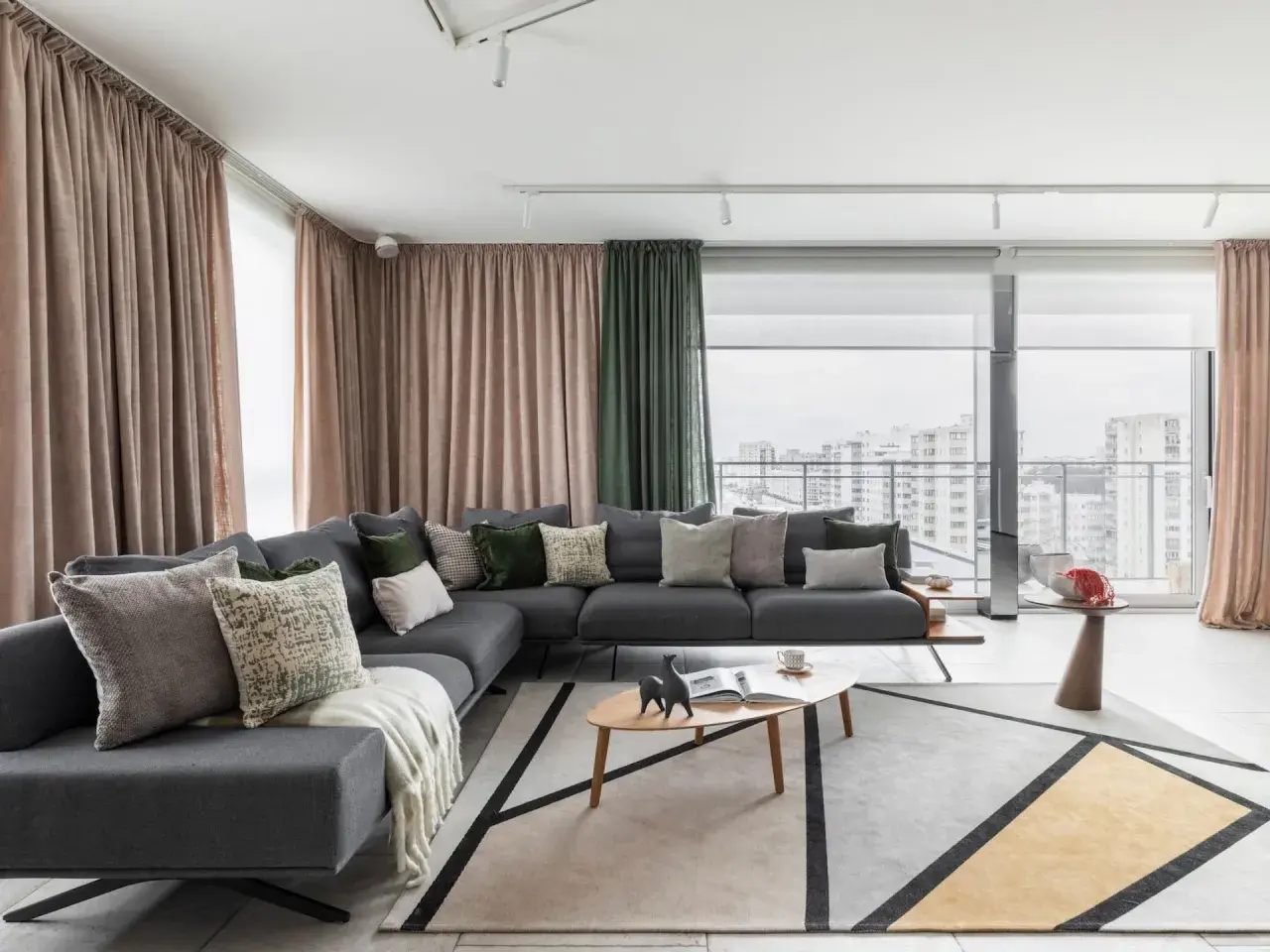 Nowoczesny salon z szarą sofą, geometrycznym dywanem i zasłonami. Idealne home staging przykłady, które zachwycają.
