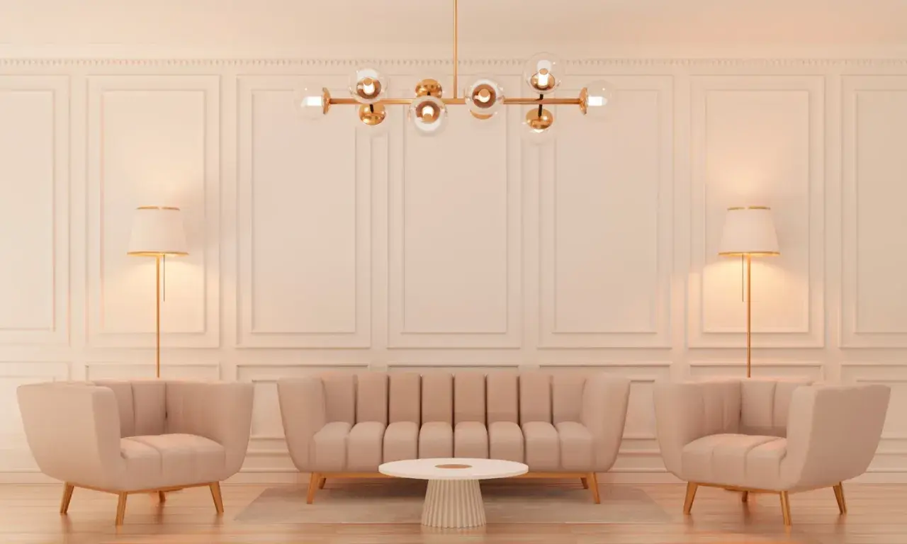 Elegancki salon w stylu glamour z beżową kanapą, dwoma fotelami, okrągłym stolikiem i złotą lampą.