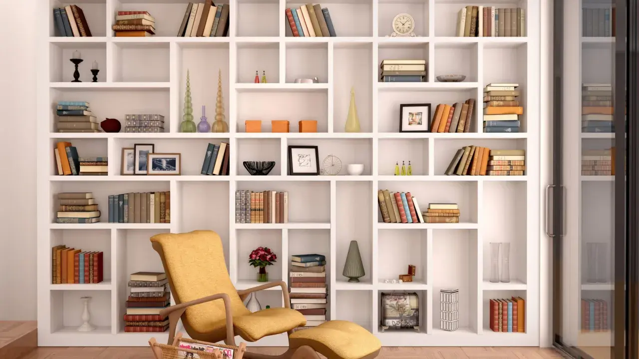 Domowa biblioteka pełna inspiracji. Wygodny fotel zachęca do czytania wśród książek i dekoracji.