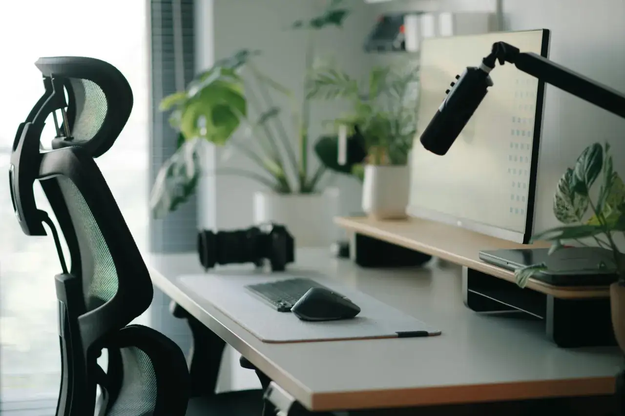 Ergonomiczne krzesło, biurko z monitorem, klawiaturą, myszką i aparatem. Rośliny dodają życia. Tak urządzić biuro, by praca była przyjemnością.