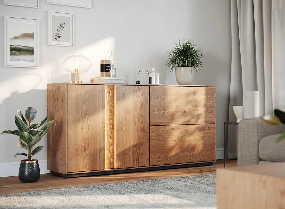 Drewniana komoda z lampą, świecą i roślinami. Świetny pomysł na dekoracje komody w nowoczesnym salonie.