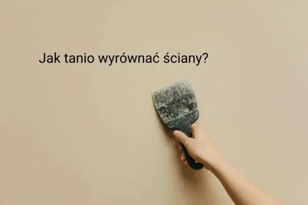 Ręka trzyma szpachelkę przy beżowej ścianie, sugerując, jak tanio wyrównać ściany.